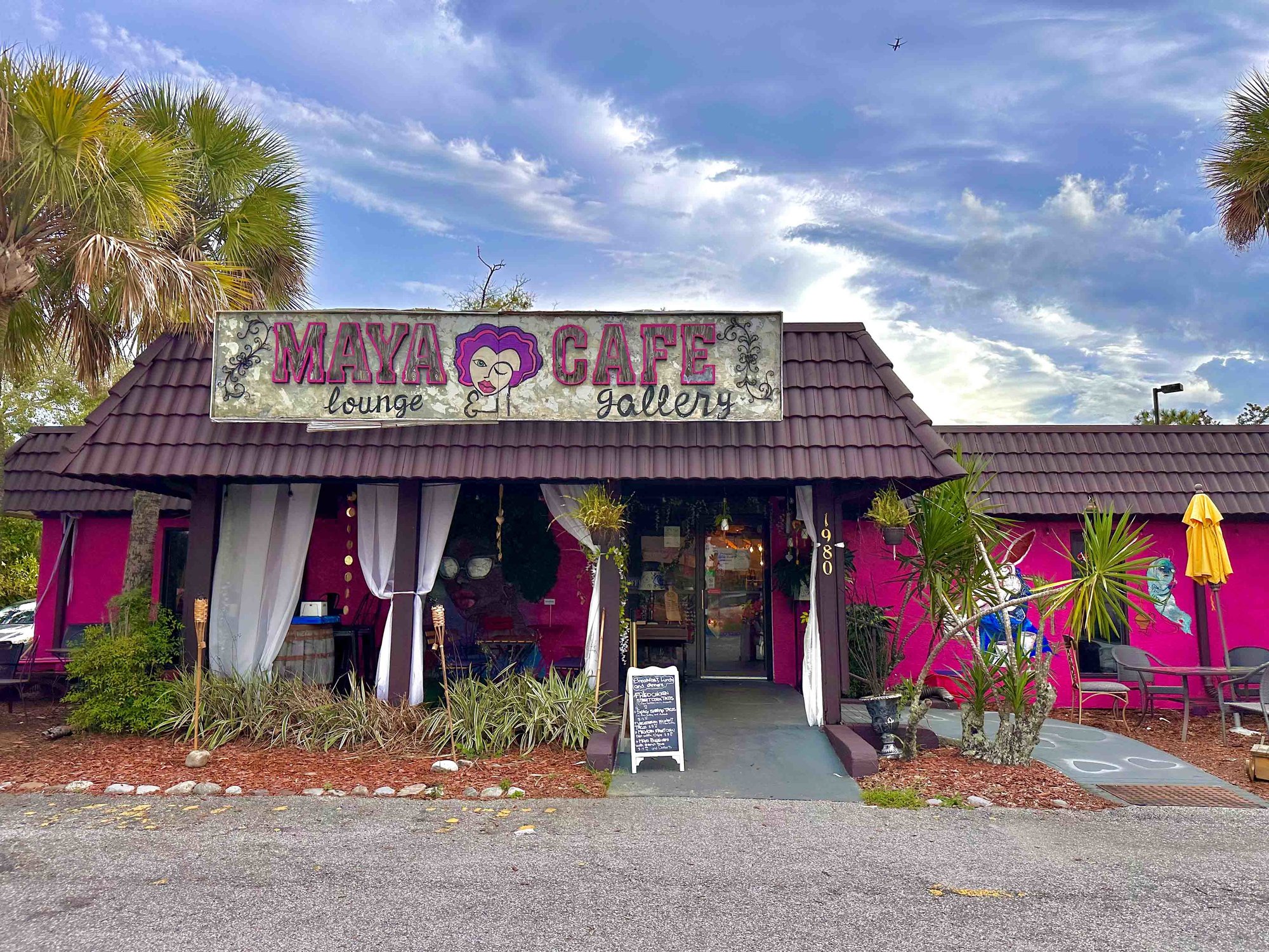 front of maya cafe with weathered sign and purple and pink paint